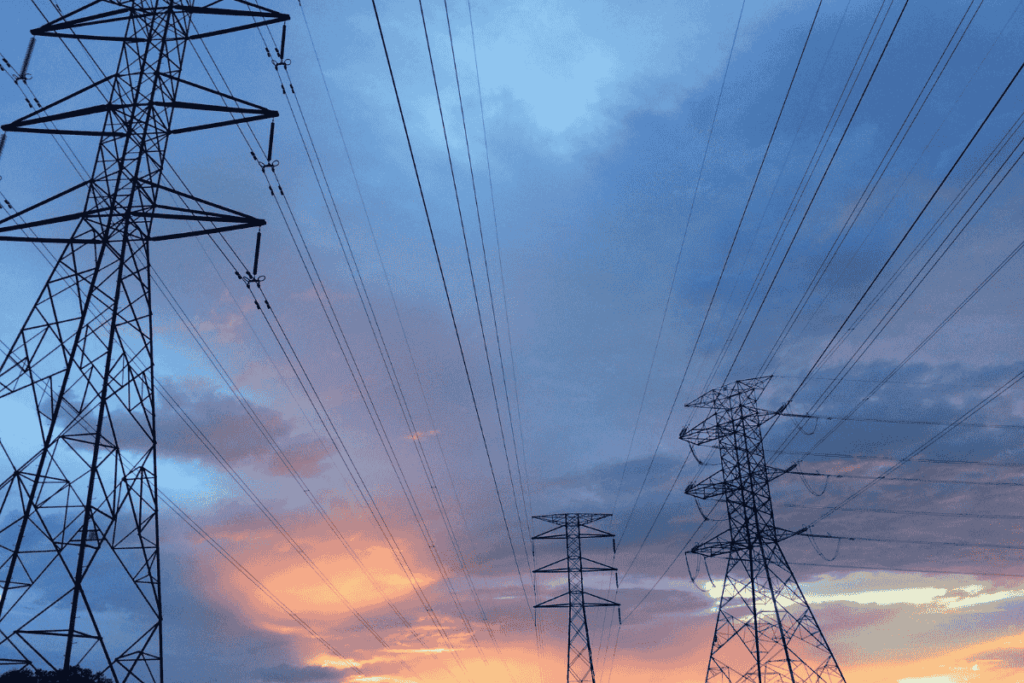 Power transmission lines during sunset, inspected by drone for utility infrastructure monitoring
