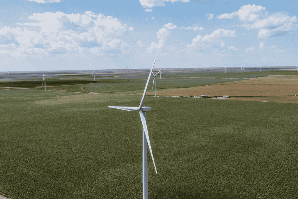Drone view of wind turbines across open farmland for renewable energy drone inspection